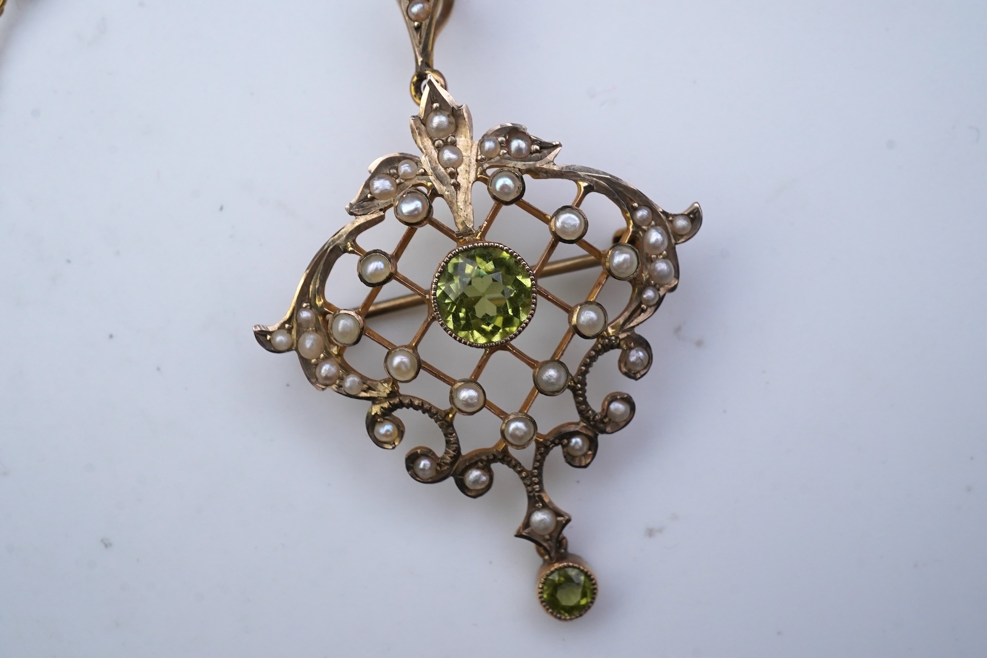 An Edwardian peridot and seed pearl pendant/brooch, early 20th century